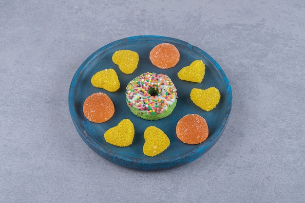 대리석 표면에 작은 도넛과 다양한 마멀레이드가 들어간 블루 플래터`