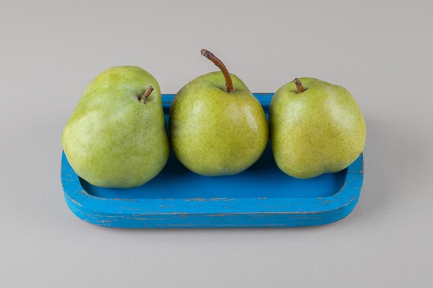 Blue platter with a handful of pears on marble 