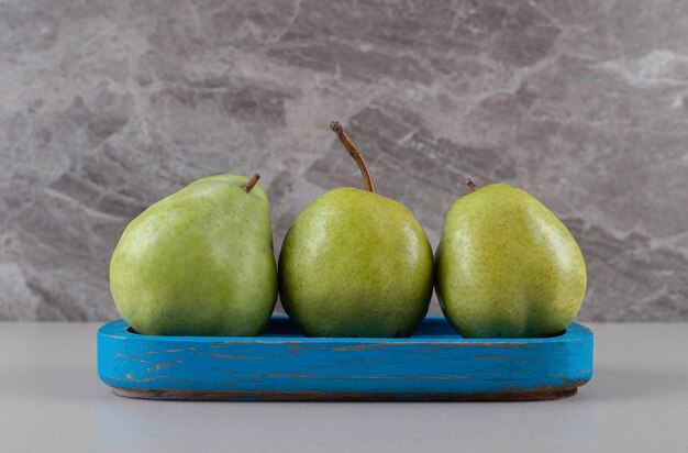 Blue platter with a handful of pears on marble 