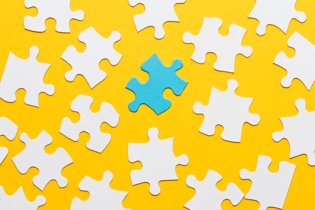 Blue puzzle with white jigsaw piece on yellow background