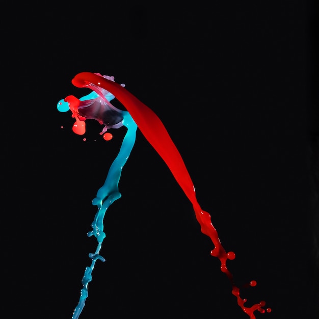 Blue and red watercolor splashing on black background