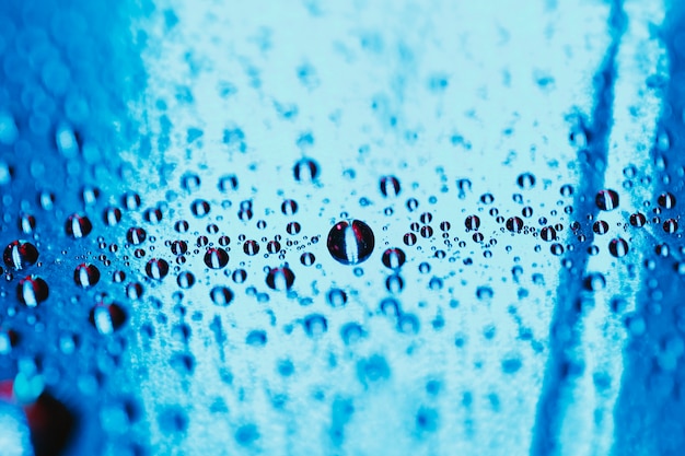 Blue reflective glass with water droplets backdrop