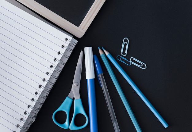 Blue school supplies with blackboard and notebook