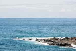 Foto gratuita mare blu con litorale roccioso