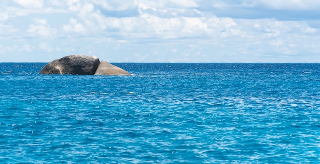 Голубое небо с морем и скалой