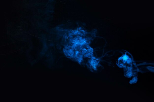 Blue smoke against black background