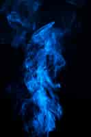 Free photo blue smoke on the center of the black background