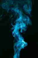 Free photo blue smoke spread on black background