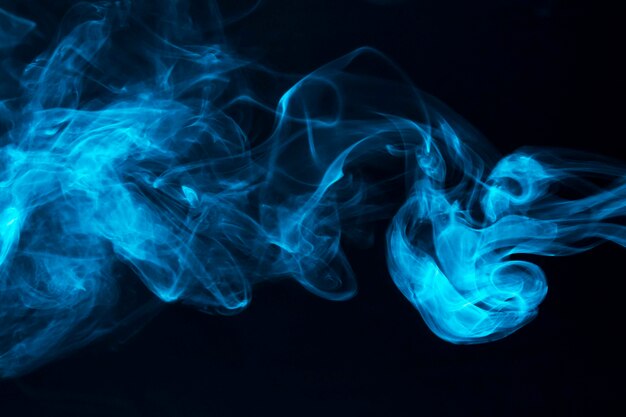 Blue smoke waves on black background