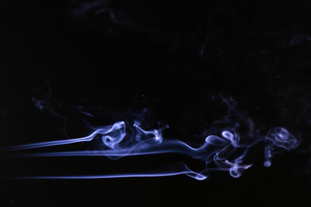 Free photo blue smoke waves on black background