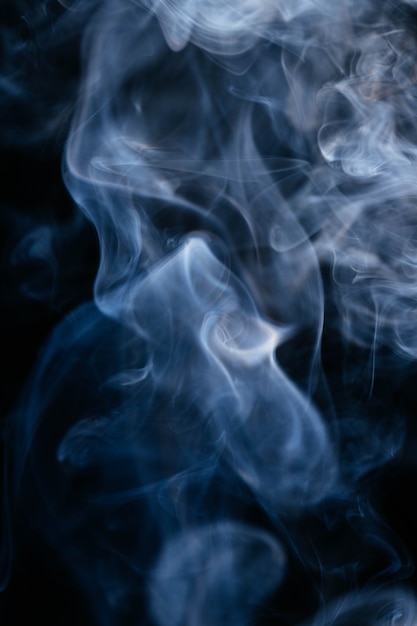 Foto gratuita onde di fumo blu su sfondo nero
