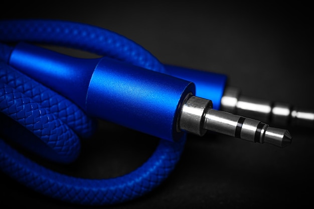 Blue speaker cable jack against a dark background