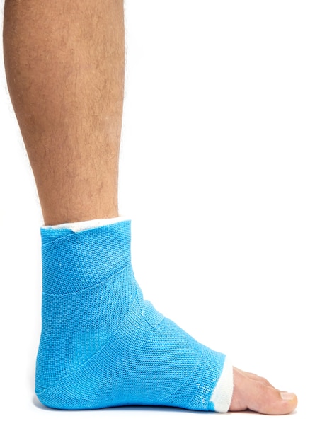 Free photo blue splint ankle. bandaged leg cast on male patient on white background isolated. sports injury concept.