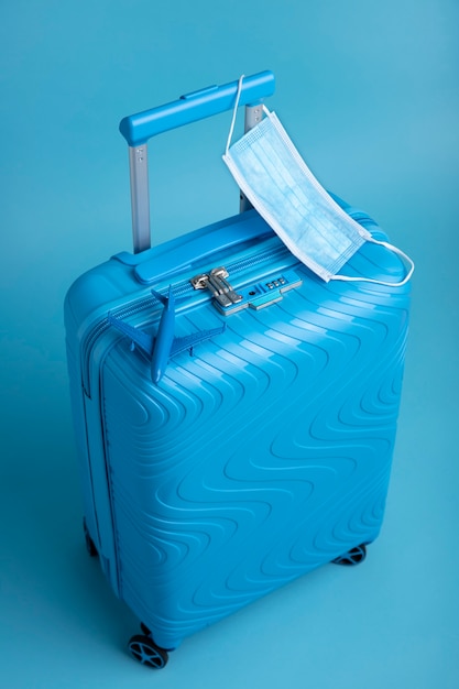 医療用マスク付き旅行用の青いスーツケース