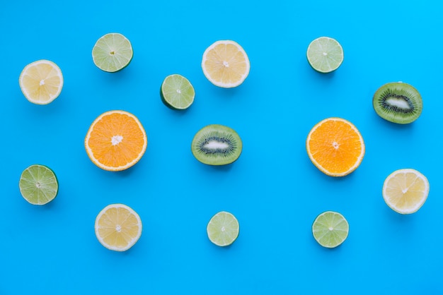 Бесплатное фото Синяя поверхность с разными фруктами, разрезанная пополам