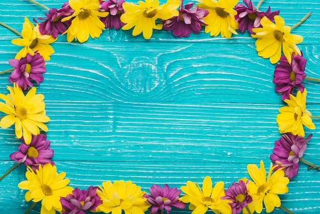 Blue surface with frame of purple and yellow flowers