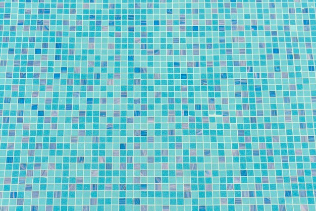 Blue swimming pool rippled water .