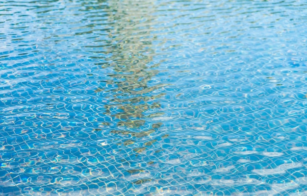 Blue swimming pool rippled water .