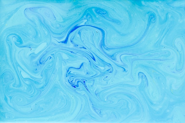 Free photo blue swirls of paint in liquid