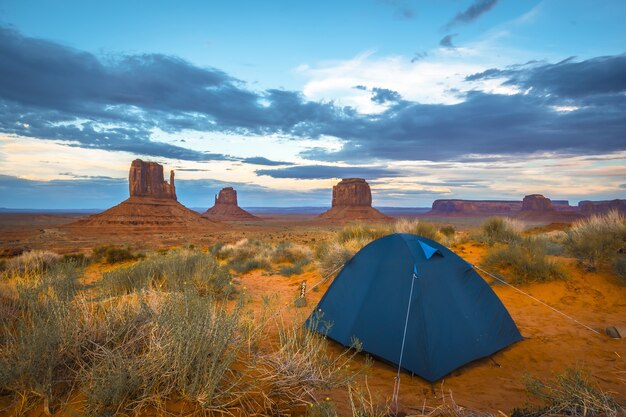 Blue tent in the famous Monument Valley in Utah, USA under a cloudy sky