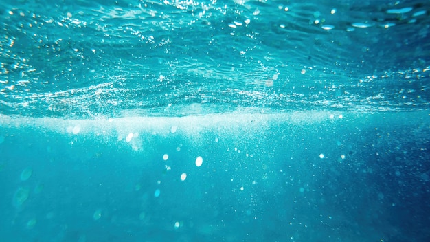 Blue and transparent water of the Mediterranean sea. Sunlight, multiple bubbles