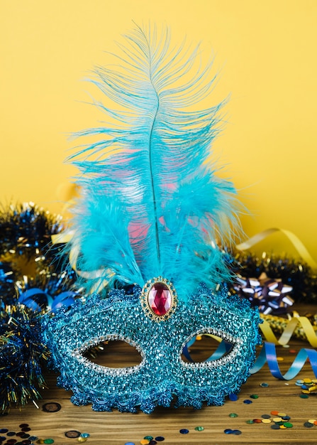 Foto gratuita maschera di carnevale veneziano blu con piuma e materiale per la decorazione del partito