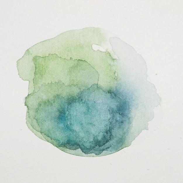 Blue and verdant paints in form of circle on white paper