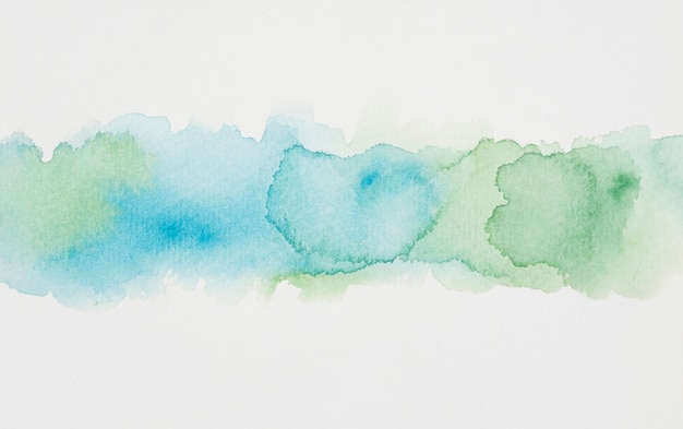 Blue and verdant spots of paints on white paper