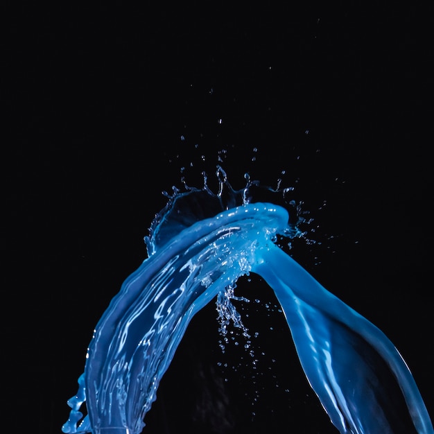 Blue water splash on black backdrop