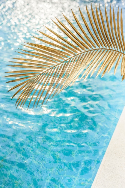 Blue water texture in a swimming pool with palm leaf