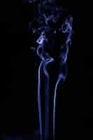 Free photo blue wavy smoke on black background