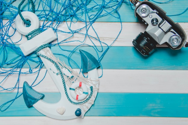 Blue and white background with camera, anchor and rope