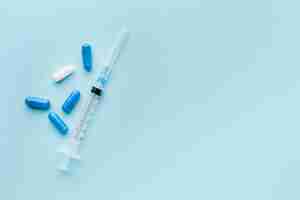 Free photo blue and white pills with syringe