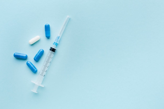 Blue and white pills with syringe