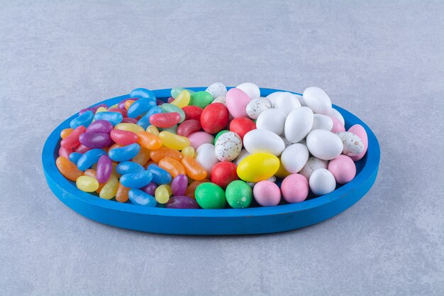 A blue wooden board of colorful sweet jelly bean candies 