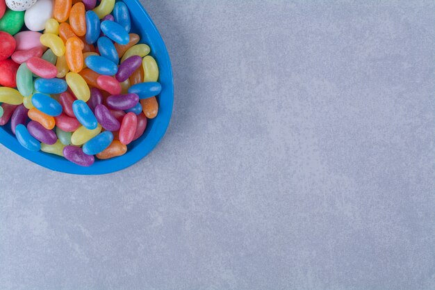A blue wooden board of colorful sweet jelly bean candies 
