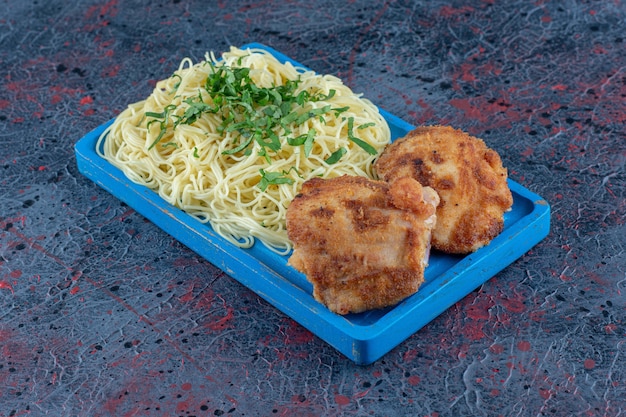 麺とチキンカツレツの青い木の板。