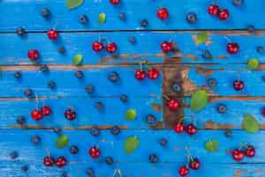 Free photo blue wooden surface with cherries and blueberries