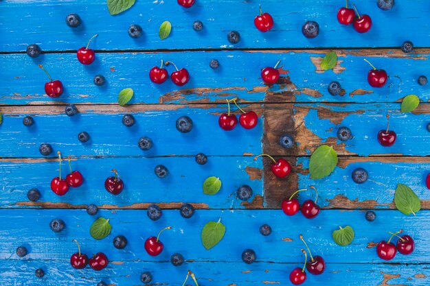 Blue wooden surface with cherries and blueberries