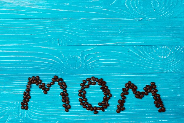 Blue wooden surface with coffee beans for mother's day