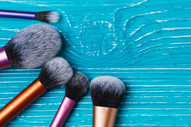 Free photo blue wooden surface with decorative make-up brushes