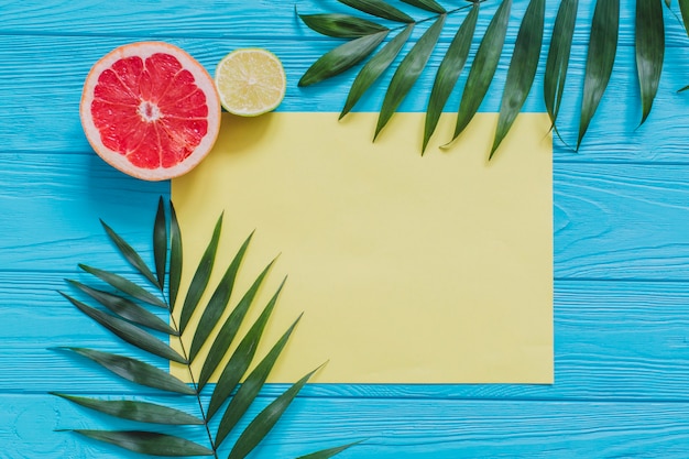 Foto gratuita superficie di legno blu con frutta estiva e carta gialla