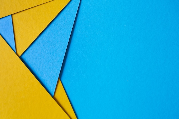 Blue and yellow, color paper geometric flat lay background.