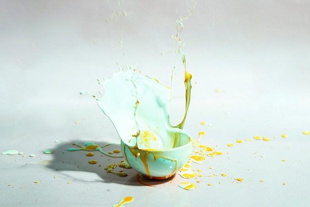 青と黄色の塗料スプラッシュとカップの抽象的な背景