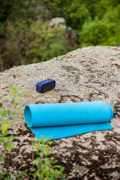 Синий коврик для йоги, беспроводной портативный динамик на скале в каньоне