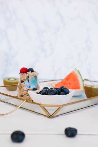 Blueberries; sliced watermelon; kiwi and oats on tray