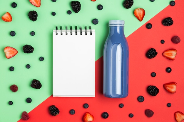 Blueberries smoothie next to empty notepad