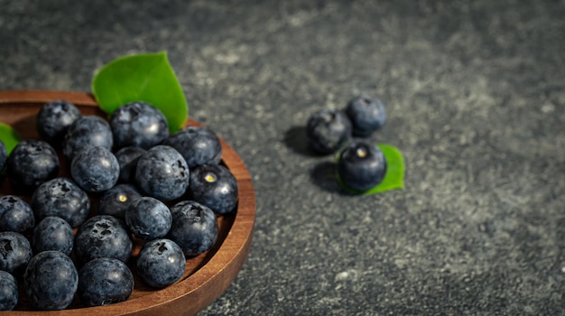 Free photo blueberries on a textured black background copy space