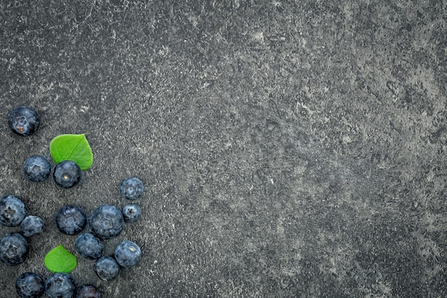 Free photo blueberries on a textured black background top view