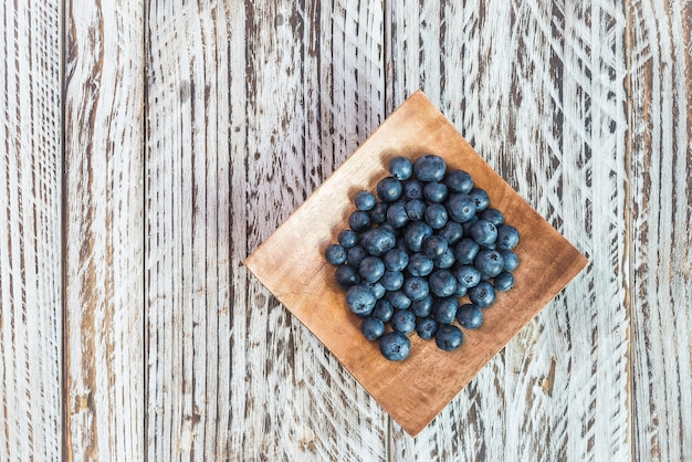 Free photo blueberries on a wooden plate